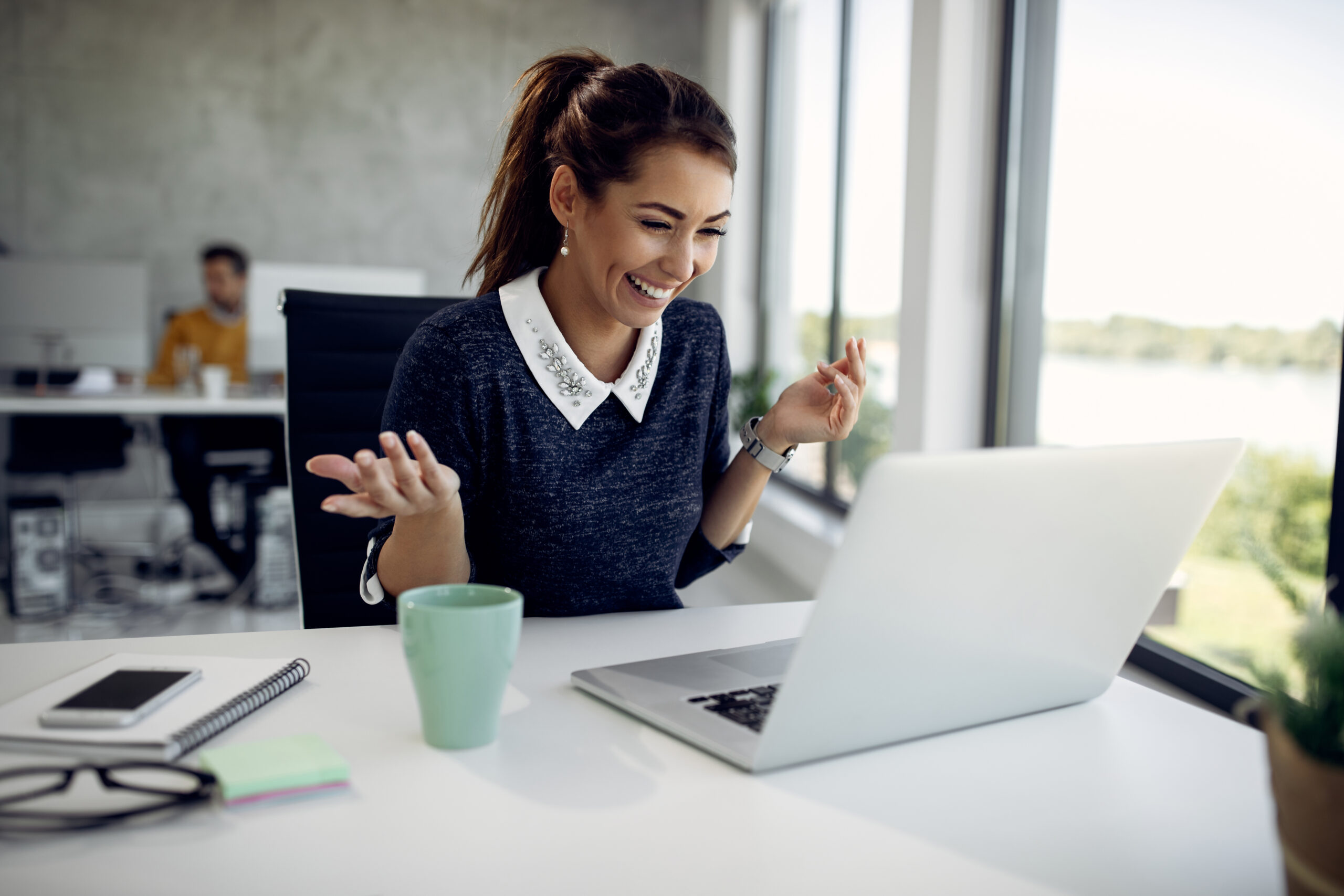 Happy businesswoman using computer and having fun during a video call in the office.